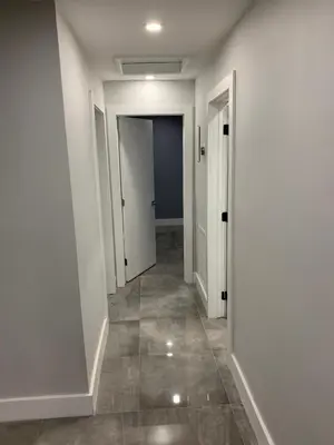 an empty hallway with white walls and tile floors at waterfront lake Hollywood hard rock Airport in Dania Beach