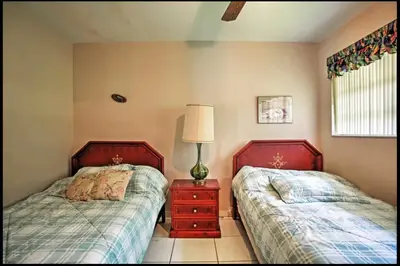 a bedroom with two beds and a lamp on a night stand at 7545 Southwest 124th Street in Miami