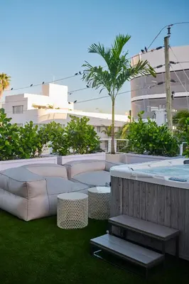 a patio with a couch and a hot tub at Hotel Greystone - Adults Only in Miami Beach