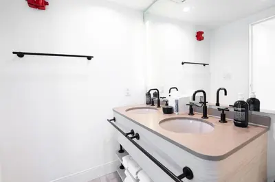 a bathroom with two sinks and two mirrors at Hotel Greystone - Adults Only in Miami Beach