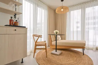 a living room with a table and a chair at Hotel Greystone - Adults Only in Miami Beach