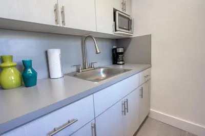 a kitchen with a sink and a microwave at 23 Palms Suites - Midtown Wynwood in Miami