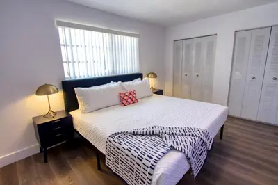 a bedroom with a bed with a black and white comforter at 23 Palms Suites - Midtown Wynwood in Miami