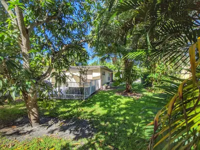 a house in the middle of a yard with trees at Flamingo Place - One block to Lauderdale Marine Center - 3 bedroom - 2 bath - King bed in Fort Lauderdale