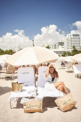 a woman sitting in chairs on a beach at Lennox Miami Beach in Miami Beach