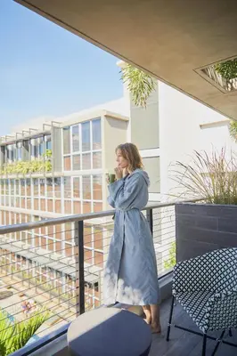 a woman standing on a balcony talking on a cell phone at Lennox Miami Beach in Miami Beach