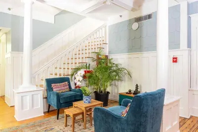a living room with two blue chairs and a table at Miami River Inn by Renzzi in Miami