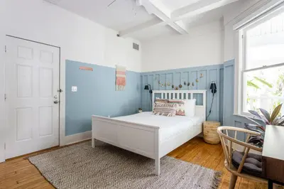 a bedroom with a white bed and blue walls at Miami River Inn by Renzzi in Miami