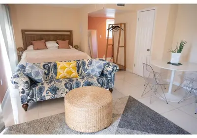 a bedroom with a bed and a couch and a table at Miami River Inn by Renzzi in Miami