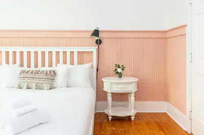 a bedroom with a white bed and a white table at Miami River Inn by Renzzi in Miami