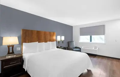 a bedroom with a large white bed and a chair at Extended Stay America Premier Suites - Miami - Downtown Brickell - Cruise Port in Miami
