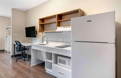 a kitchen with a white refrigerator and a desk at Extended Stay America Premier Suites - Miami - Coral Gables in Miami