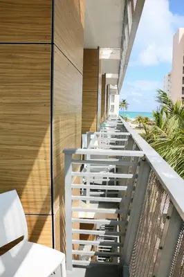 a balcony with white chairs and a view of the beach at The Local House in Miami Beach