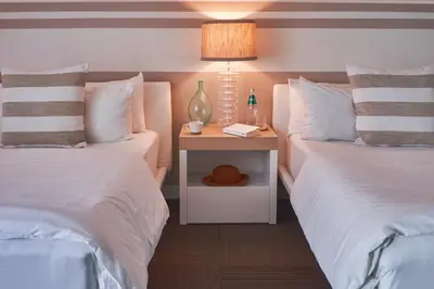 a bedroom with two beds and a night stand with a lamp at The Local House in Miami Beach