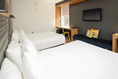 a hotel room with two beds and a flat screen tv at Aloft Miami Doral in Miami