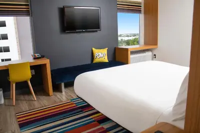 a bedroom with a bed and a desk and a tv at Aloft Miami Doral in Miami