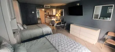 a hotel room with two beds and a kitchen and a living room at Miami Direct Access to the beach in Miami Beach