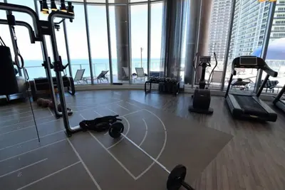 a gym with exercise equipment in a building with windows at Lyfe-3308 in Hollywood