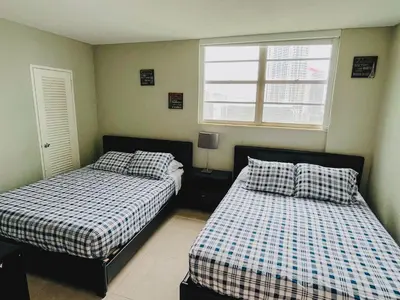 a bedroom with two beds and a window at Hallandale Condo, Partial Ocean View Direct Beach and Pool Access Hollywood Beach in Hollywood