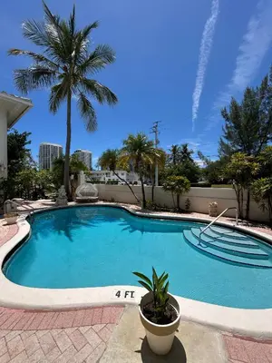 a large swimming pool with a palm tree in the background at La Casa Hotel in Fort Lauderdale