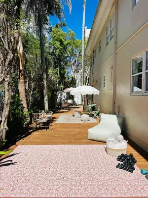 a large rug on a wooden floor next to a building at La Casa Hotel in Fort Lauderdale