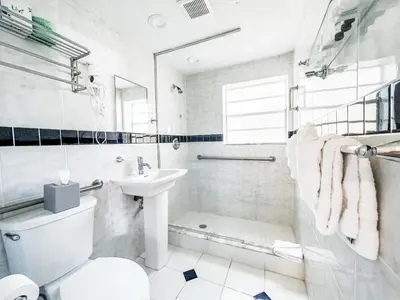 a white bathroom with a toilet and a sink at La Casa Hotel in Fort Lauderdale