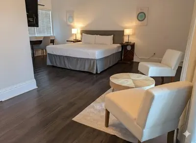 a hotel room with a bed and a living room at La Casa Hotel in Fort Lauderdale