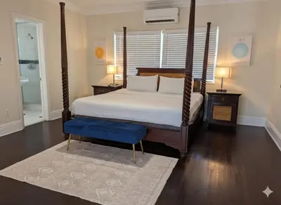 a bedroom with a canopy bed with a blue stool at La Casa Hotel in Fort Lauderdale