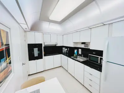 a white kitchen with a sink and a refrigerator at Hallandale Beach Partial Ocean View Apartments in Hollywood