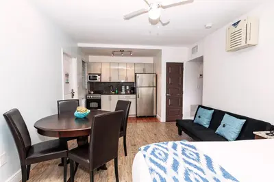 a dining room and living room with a table and chairs at Caribbean Resort Suites in Hollywood