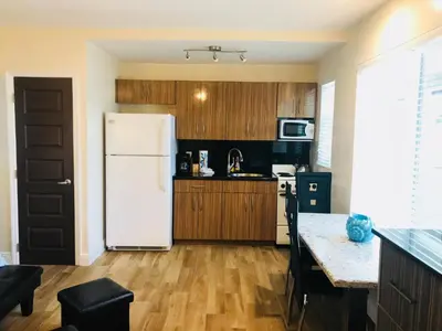a kitchen with a white refrigerator and wooden cabinets at Caribbean Resort Suites in Hollywood