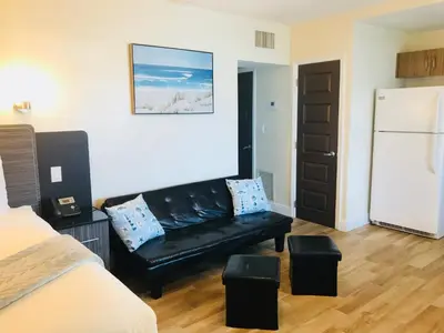 a living room with a black couch and a refrigerator at Caribbean Resort Suites in Hollywood