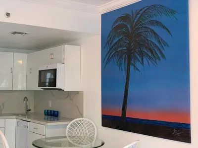 a palm tree mural on the wall of a kitchen at Luxury white loft on Ocean Drive-South beach with a view in Miami Beach