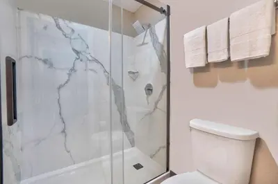 a bathroom with a shower and a white toilet at Motel 6-Fort Lauderdale, FL in Fort Lauderdale