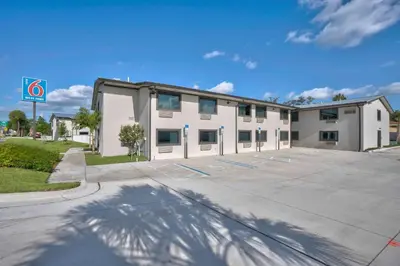 a large white building with a parking lot at Motel 6-Fort Lauderdale, FL in Fort Lauderdale