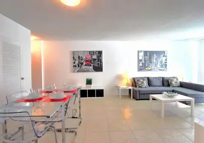 a living room with a table and a blue couch at Hallandale Beach Intracoastal View Apartments in Hollywood