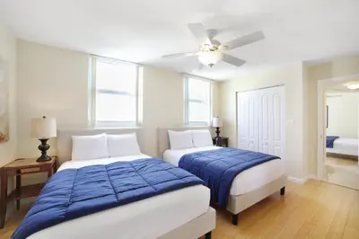a bedroom with two beds and a ceiling fan at Miami Downtown City view 3BR Air Hockey &Ping Pong table in Miami