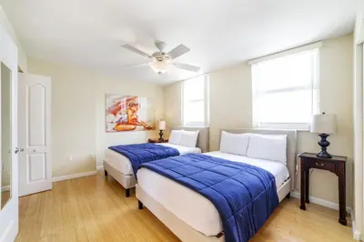 a bedroom with two beds and a ceiling fan at Miami Downtown City view 3BR Air Hockey &Ping Pong table in Miami