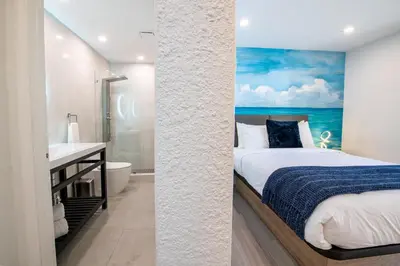 a bedroom with a bed and a bathroom at The Lauderdale Boutique Hotel in Fort Lauderdale