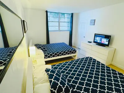 a small room with two beds and a television at Miami Hollywood 2 Bedroom Garden View 001-21mar in Hollywood