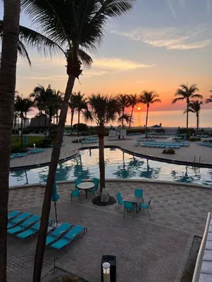 a view of a pool with palm trees and a sunset at Miami Hollywood 2 Bedroom Garden View 001-21mar in Hollywood