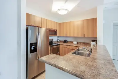 a kitchen with wooden cabinets and a stainless steel refrigerator at Dadeland Towers by Miami Vacations in South Miami