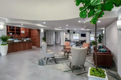 an office lobby with chairs and a table at Four Points by Sheraton Fort Lauderdale Airport - Dania Beach in Dania Beach