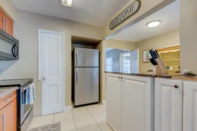 a kitchen with white cabinets and a stainless steel refrigerator at The oasis near the cruise & airport - By Avi in Fort Lauderdale