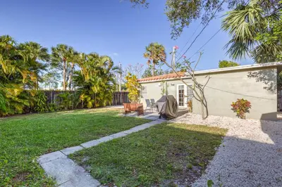 a small white house with a grass yard at The oasis near the cruise & airport - By Avi in Fort Lauderdale
