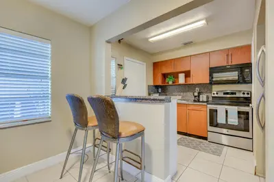a kitchen with two bar stools at a counter at The oasis near the cruise & airport - By Avi in Fort Lauderdale