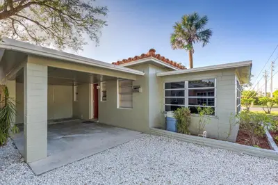 a house with a garage and a palm tree at The oasis near the cruise & airport - By Avi in Fort Lauderdale