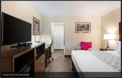 a hotel room with a bed and a flat screen tv at Downtown Hollywood Gardens Inn & Suites in Hollywood