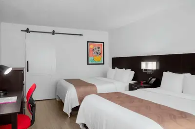 a hotel room with two beds and a desk at Quality Inn Miami South in Kendall