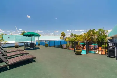 a patio with chairs and an umbrella and the ocean at Quality Inn Miami South in Kendall